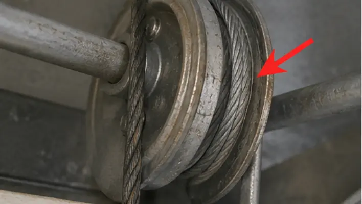 Worn garage door cable creating grinding noise while wrapped around torsion drum